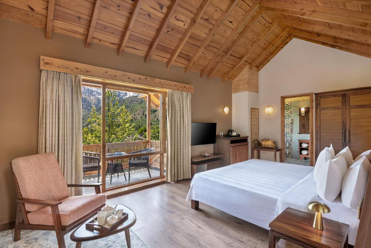a bedroom with a large bed and a balcony at Welcomhotel By ITC Hotels, Hamsa Manali in Manāli a bedroom with a large bed and a balcony at Welcomhotel By ITC Hotels, Hamsa Manali in Manāli