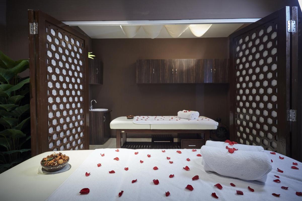 a room with a bed with red rose petals on it at Turyaa Chennai - OMR IT Expressway in Chennai