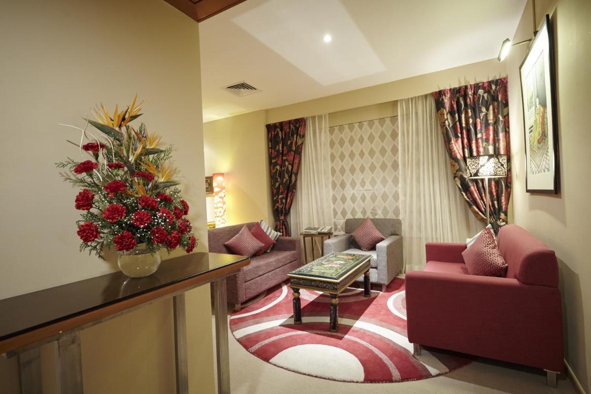 a living room with a couch and chairs and a christmas tree at Turyaa Chennai - OMR IT Expressway in Chennai
