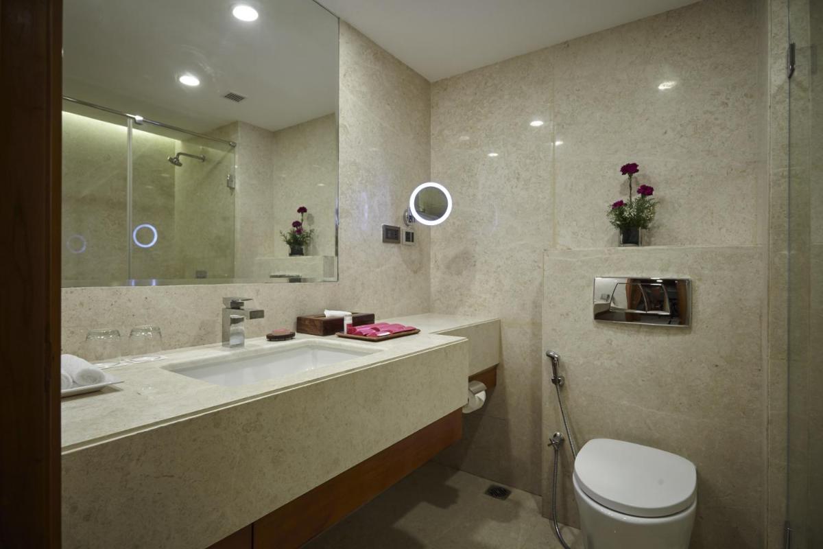 a bathroom with a sink and a toilet and a mirror at Turyaa Chennai - OMR IT Expressway in Chennai