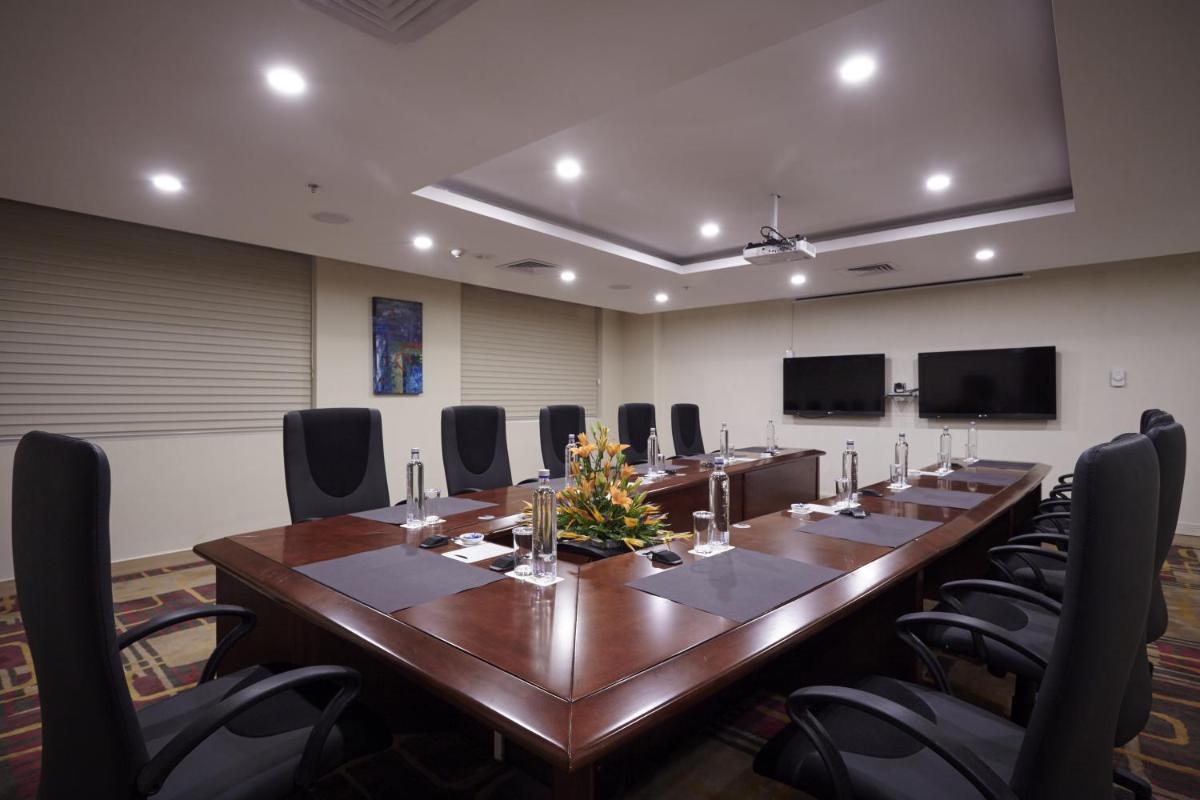 a large conference room with a long table and chairs at Turyaa Chennai - OMR IT Expressway in Chennai +21 photos