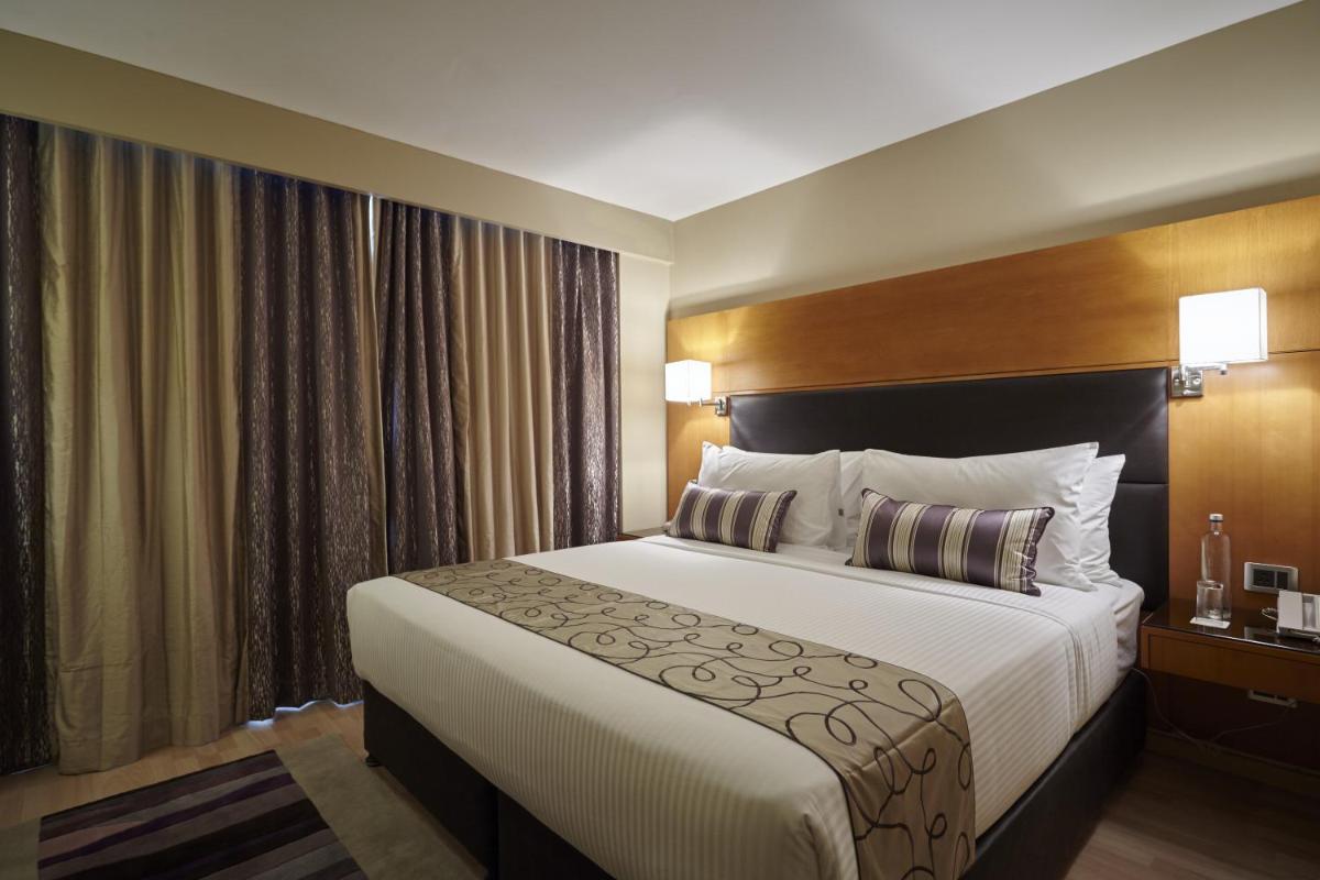 a bedroom with a large bed in a hotel room at Turyaa Chennai - OMR IT Expressway in Chennai