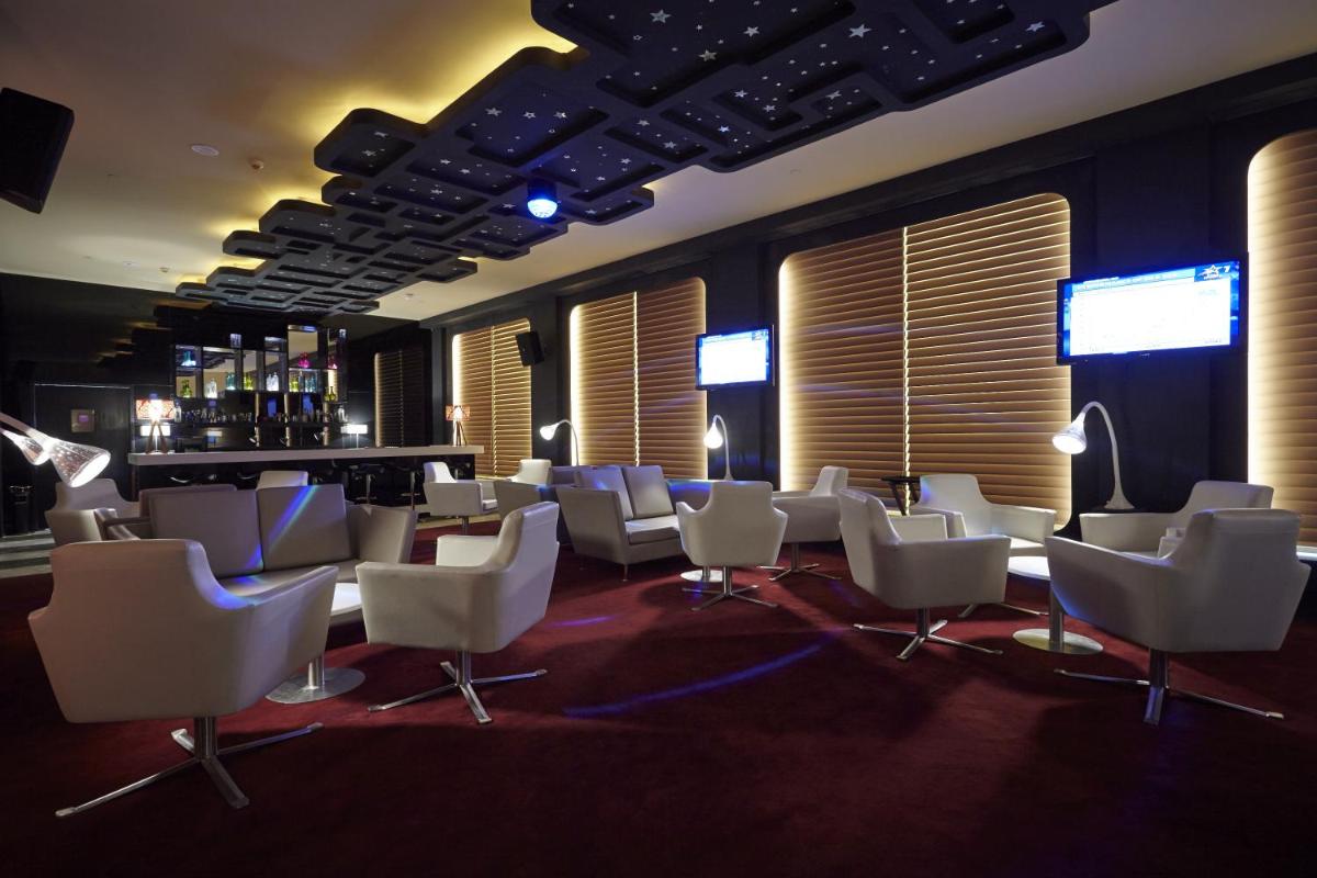a room filled with white chairs and a bar at Turyaa Chennai - OMR IT Expressway in Chennai