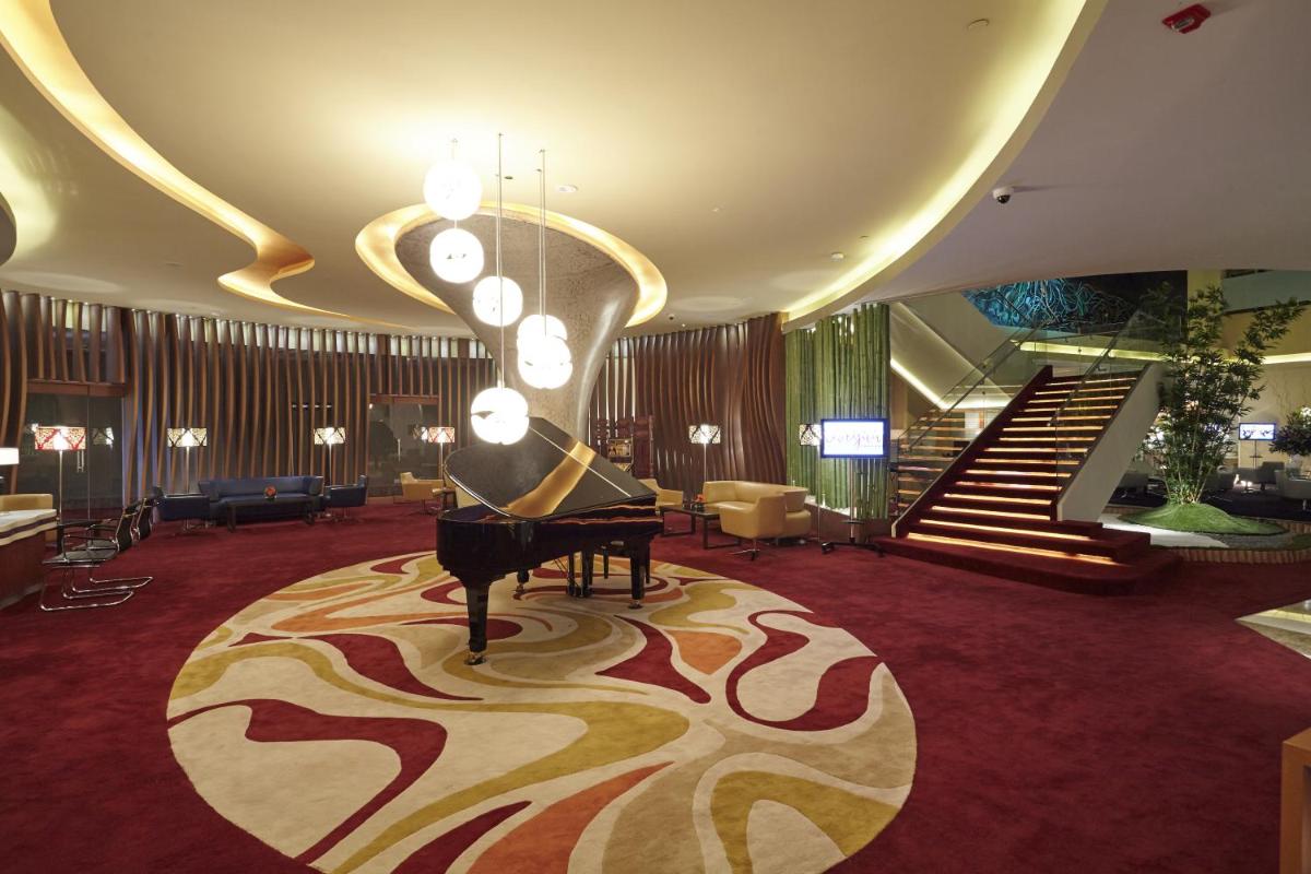a lobby with a grand piano and a staircase at Turyaa Chennai - OMR IT Expressway in Chennai