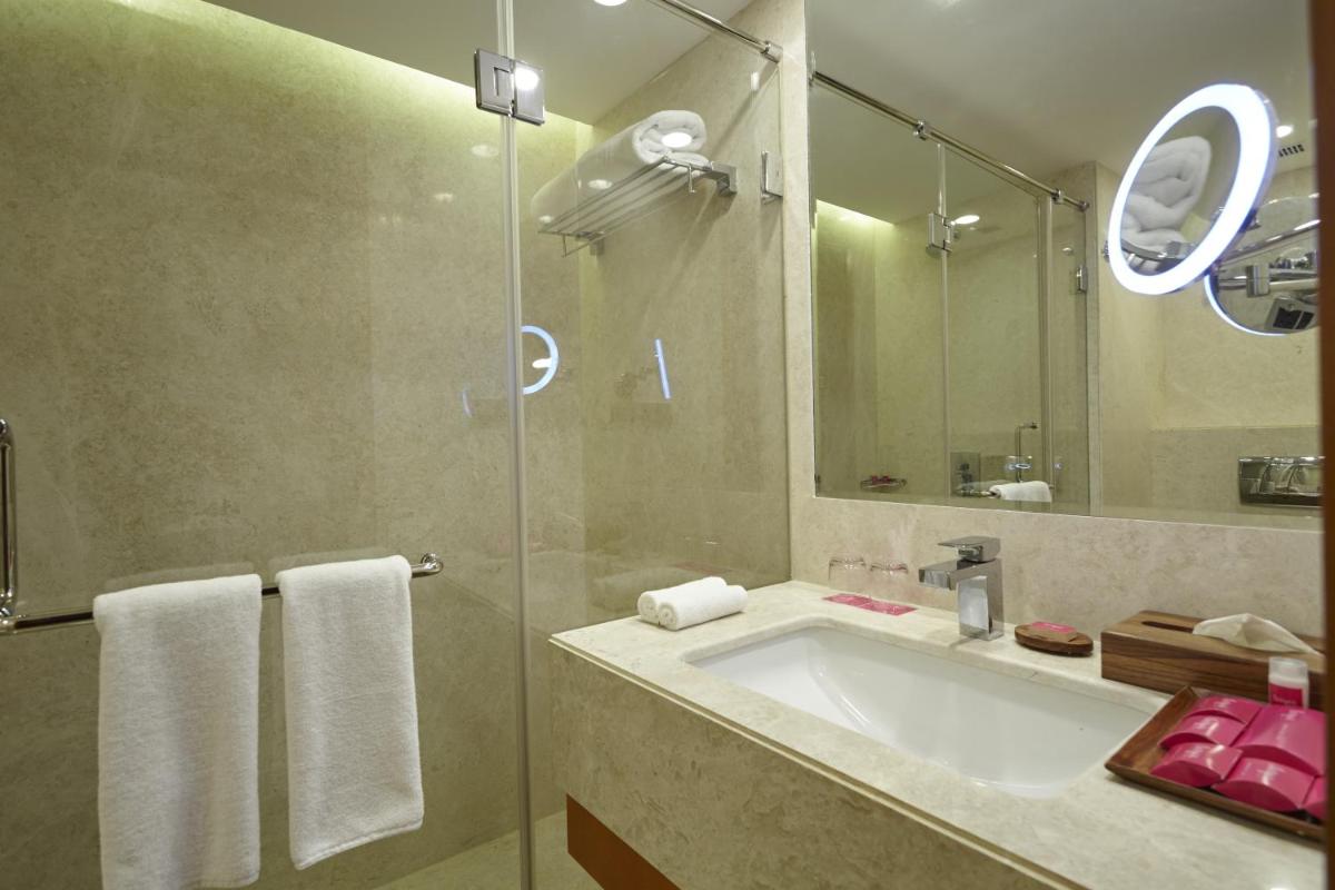 a bathroom with a sink and a glass shower at Turyaa Chennai - OMR IT Expressway in Chennai