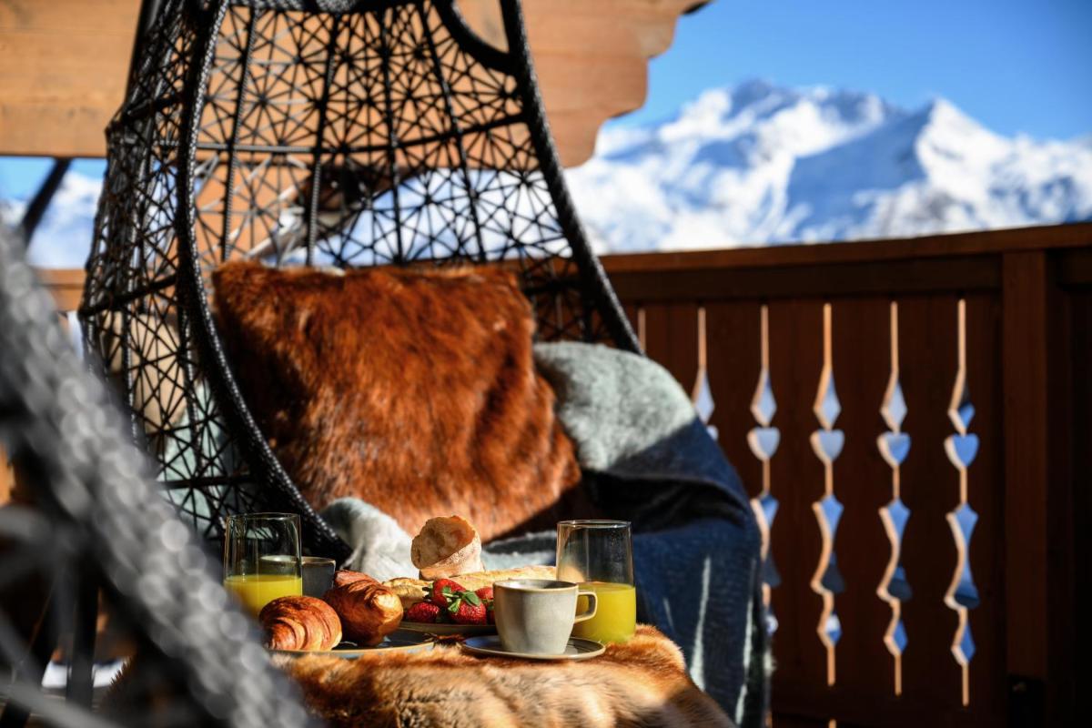 une table avec une assiette de nourriture et de boissons et une tour dans l'établissement Six Senses Residences & Spa Courchevel, à Courchevel