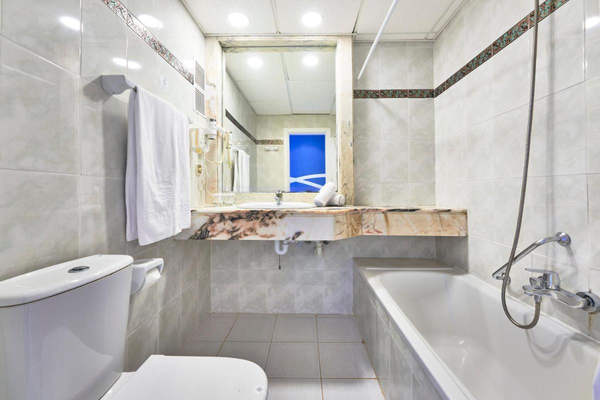 Un baño con bañera, inodoro y lavabo. en Hotel Clumba, en Cala Ratjada