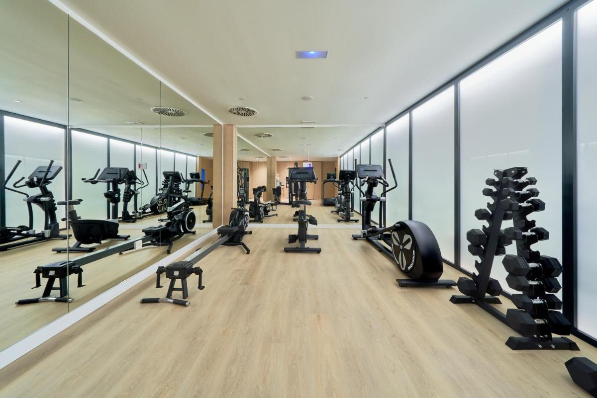 Un gimnasio con cintas de correr y equipos de ejercicio en un edificio. en Eurostars Oasis Marbella, en Marbella