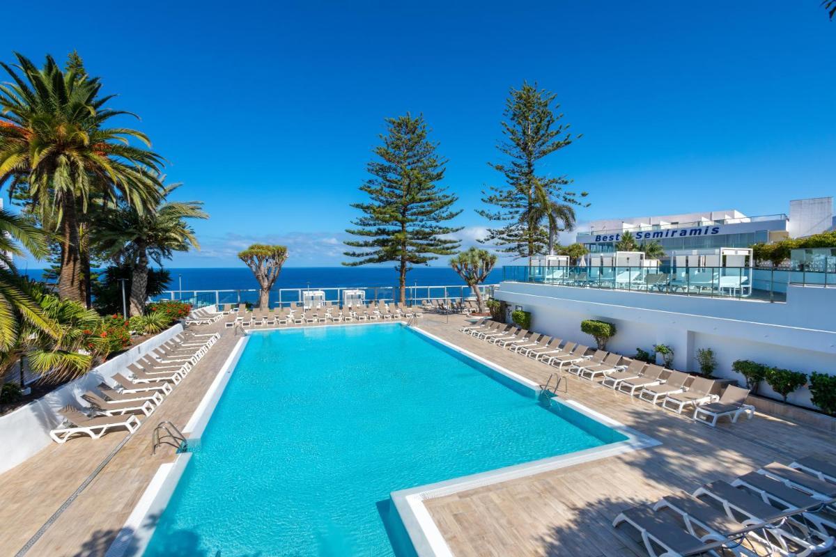 Una piscina con tumbonas y el océano. en Hotel Best Semiramis, en Puerto de la Cruz