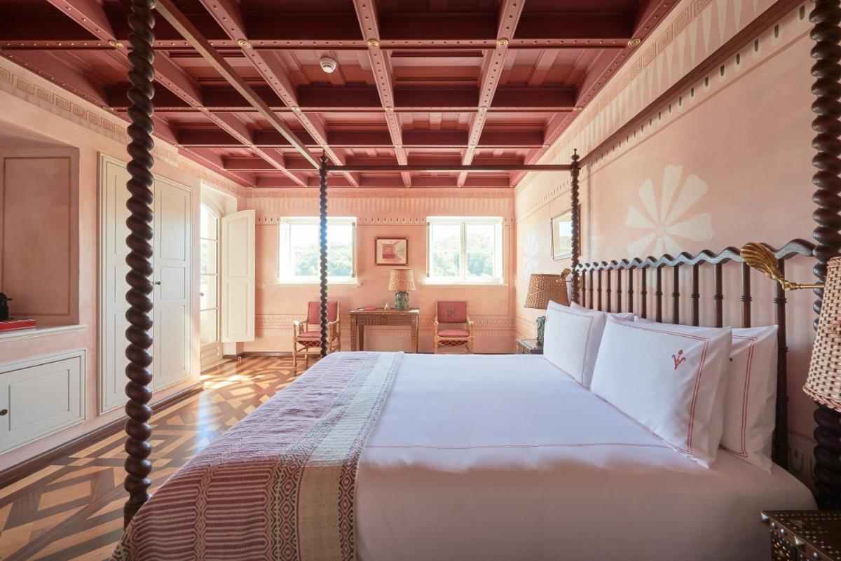 um quarto com uma cama de dossel e uma secretária em Vermelho Melides - Relais & Châteaux em Melides