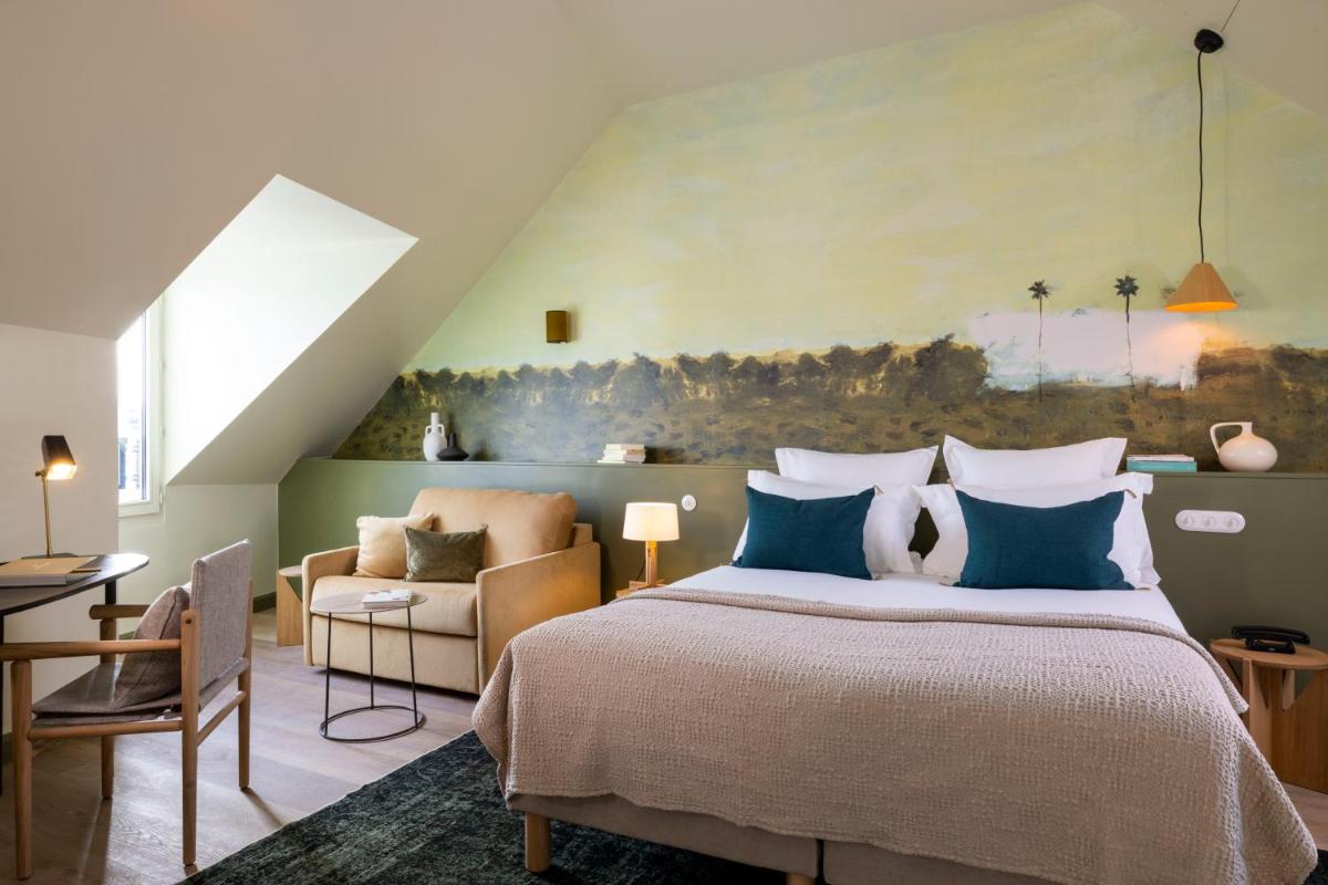 une chambre avec un grand lit avec un tableau au mur dans l'établissement Le Petit Oberkampf Hotel & Spa, à Paris