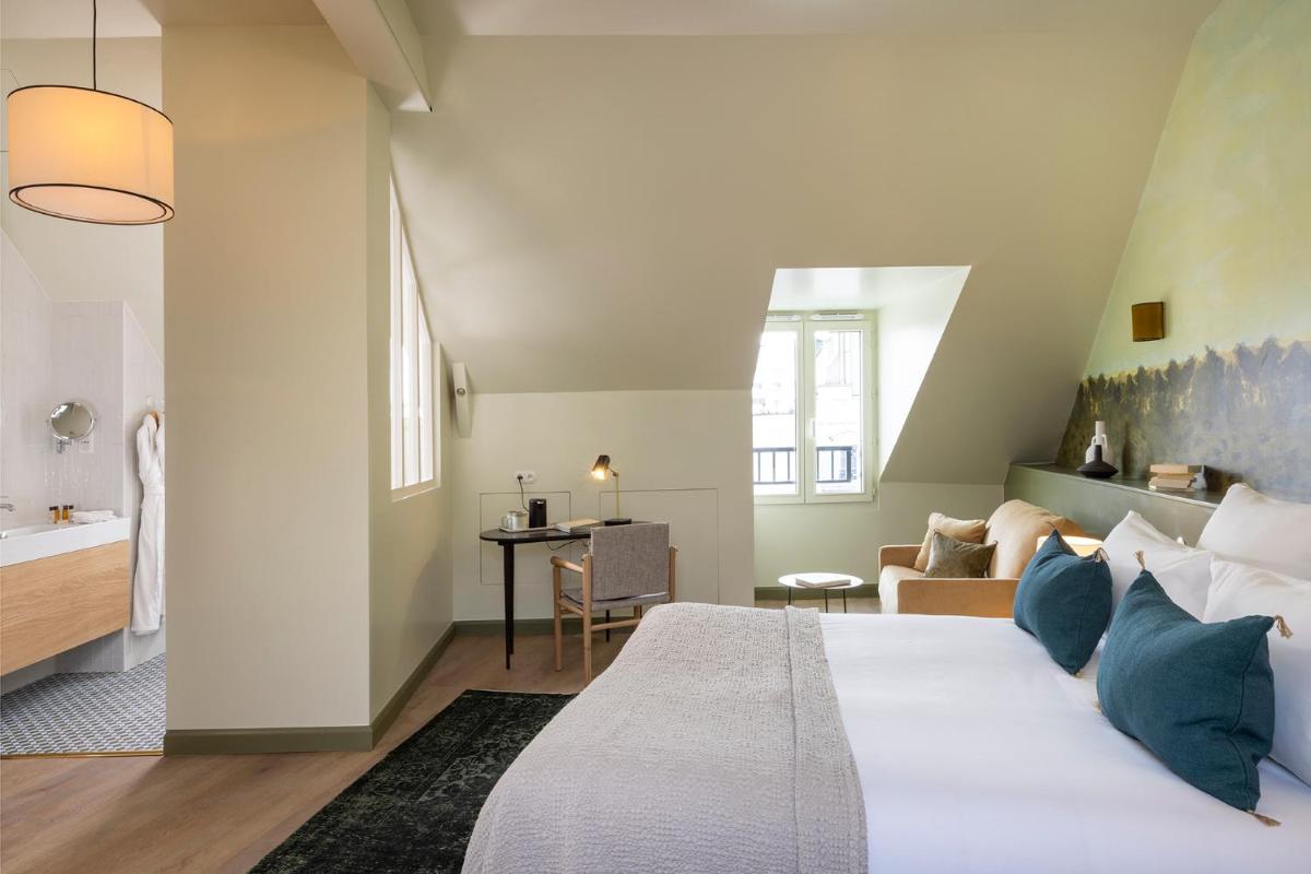 une chambre avec un grand lit et un salon dans l'établissement Le Petit Oberkampf Hotel & Spa, à Paris