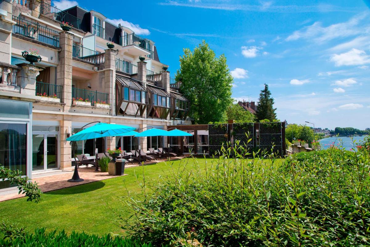 un hôtel avec une pelouse devant un bâtiment dans l'établissement La Côte Saint Jacques, à Joigny