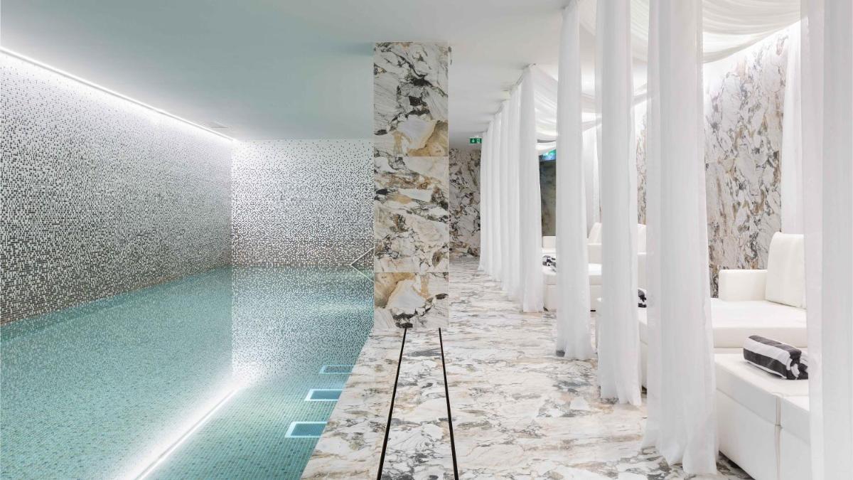 uma casa de banho com uma piscina turquesa em Wine & Books Porto Hotel - Small Luxury Hotels Of The World no Porto