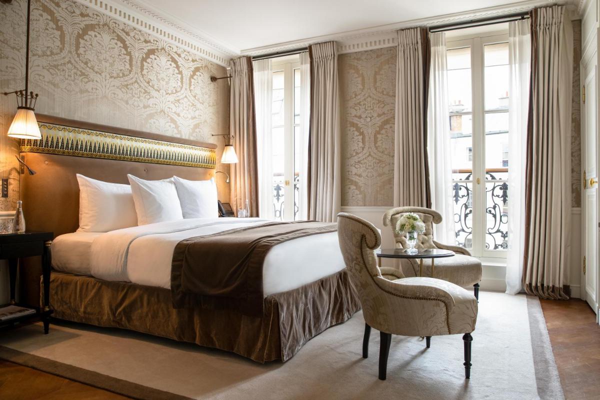 une chambre d'hôtel avec un lit et une chaise dans l'établissement La Réserve Paris Hotel & Spa, à Paris