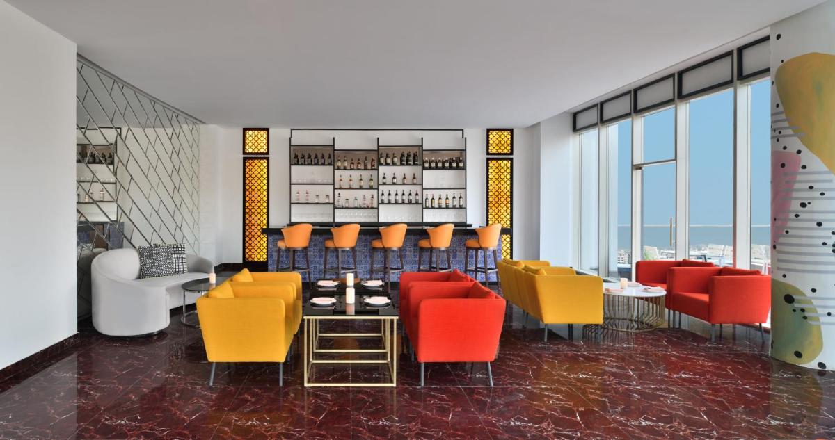 a dining room with colorful chairs and a table at Le Meridien Hyderabad in Hyderabad