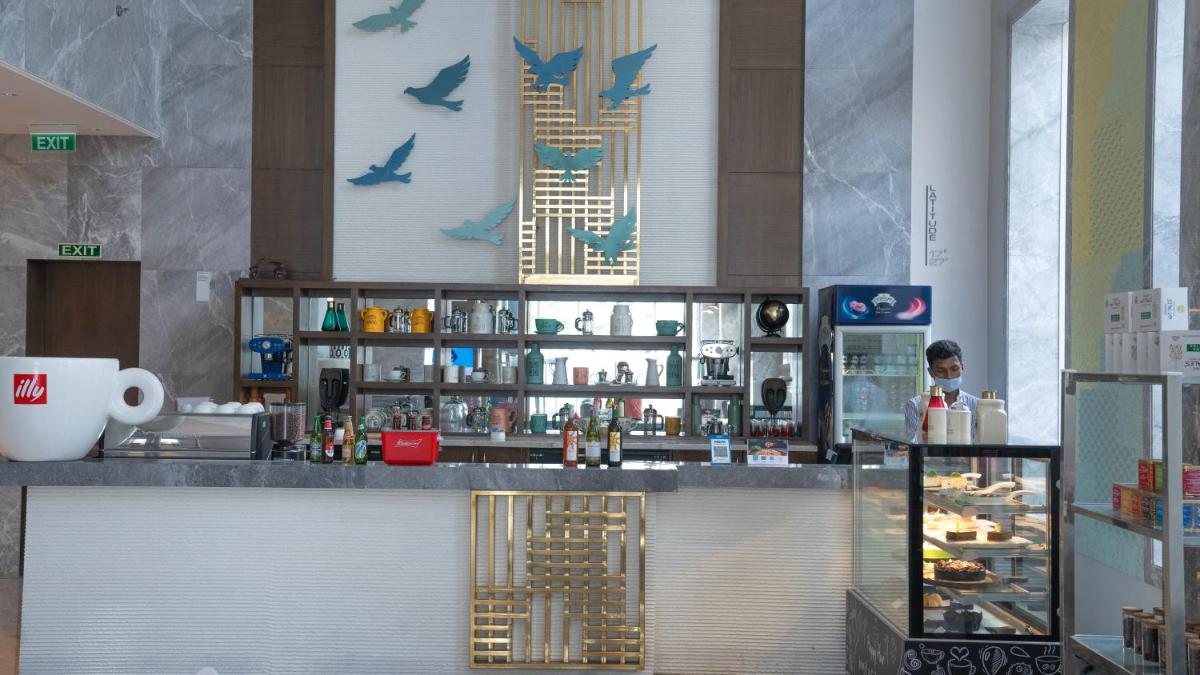 a restaurant with a bar with birds on the wall at Le Meridien Hyderabad in Hyderabad