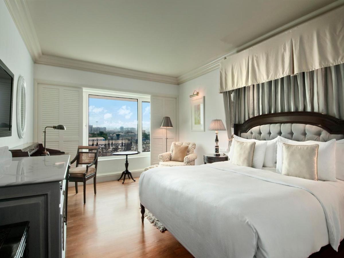 a bedroom with a large white bed and a desk at Hilton Mumbai International Airport Hotel in Mumbai