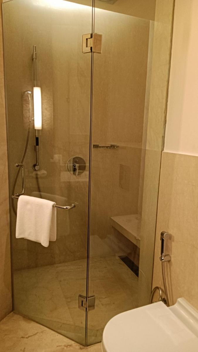 a shower with a glass door in a bathroom at The Anya Hotel-Golf Course Road in Gurgaon