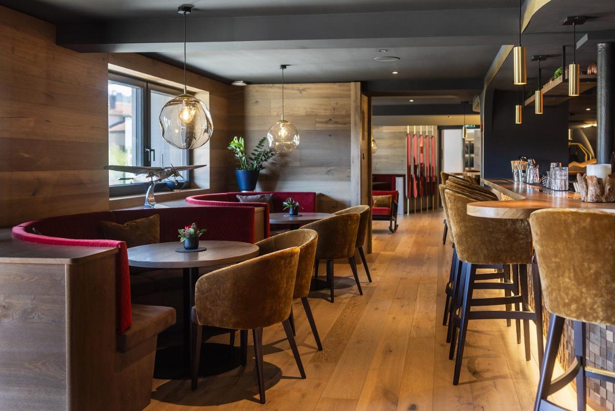 ein Restaurant mit Tischen und Stühlen und eine Bar in der Unterkunft Hotel Franks in Oberstdorf