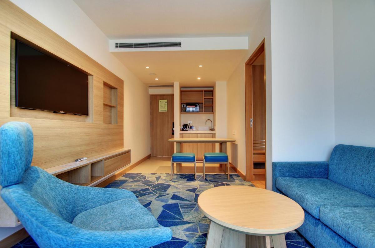 a living room with a couch and a table at Holiday Inn Bengaluru Racecourse by IHG in Bengaluru a living room with a couch and a table at Holiday Inn Bengaluru Racecourse by IHG in Bengaluru