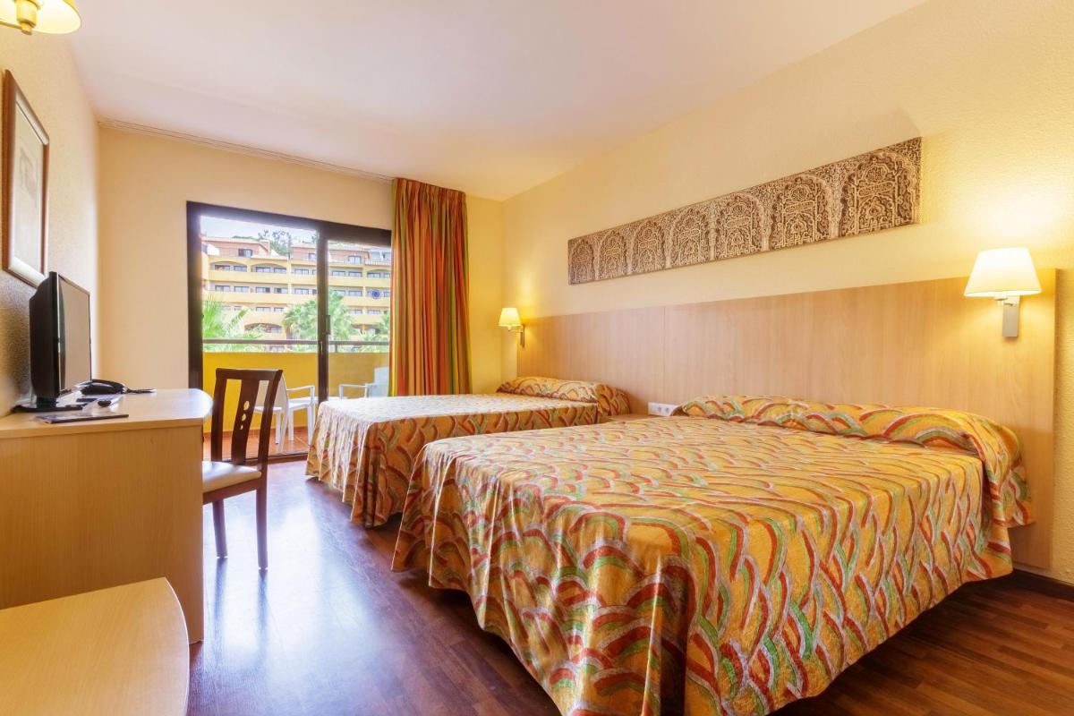 Una habitación de hotel con dos camas y un televisor. en Hotel Best Alcázar, en La Herradura