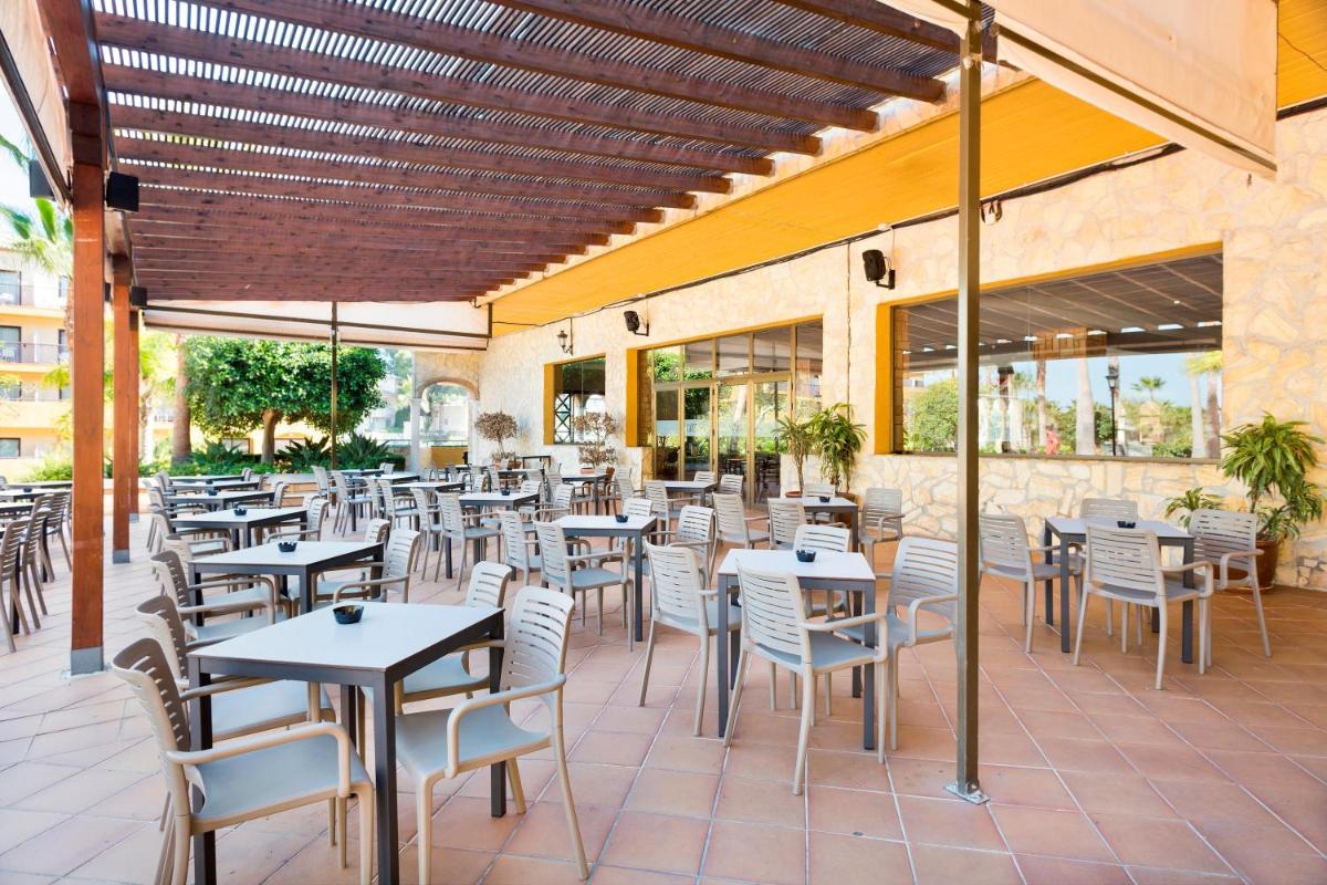 un restaurante vacío con mesas y sillas en un patio en Apartamentos Best Alcazar, en La Herradura 49 fotos más