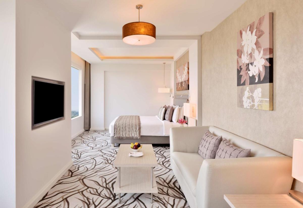 a living room with a couch and a bed at Radisson Blu Bengaluru Outer Ring Road in Bengaluru