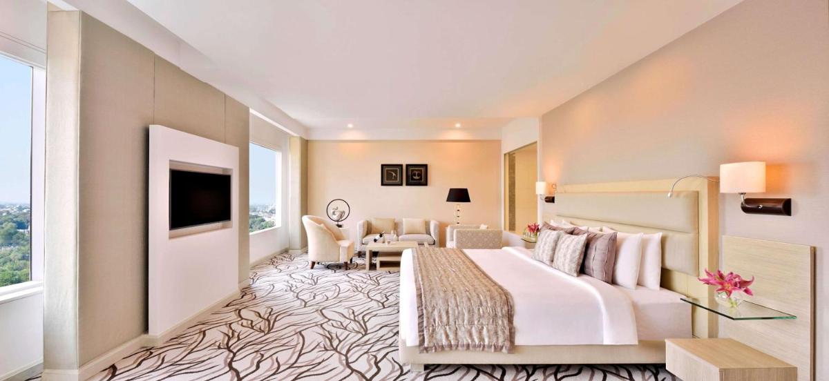 a hotel room with a bed and a living room at Radisson Blu Bengaluru Outer Ring Road in Bengaluru