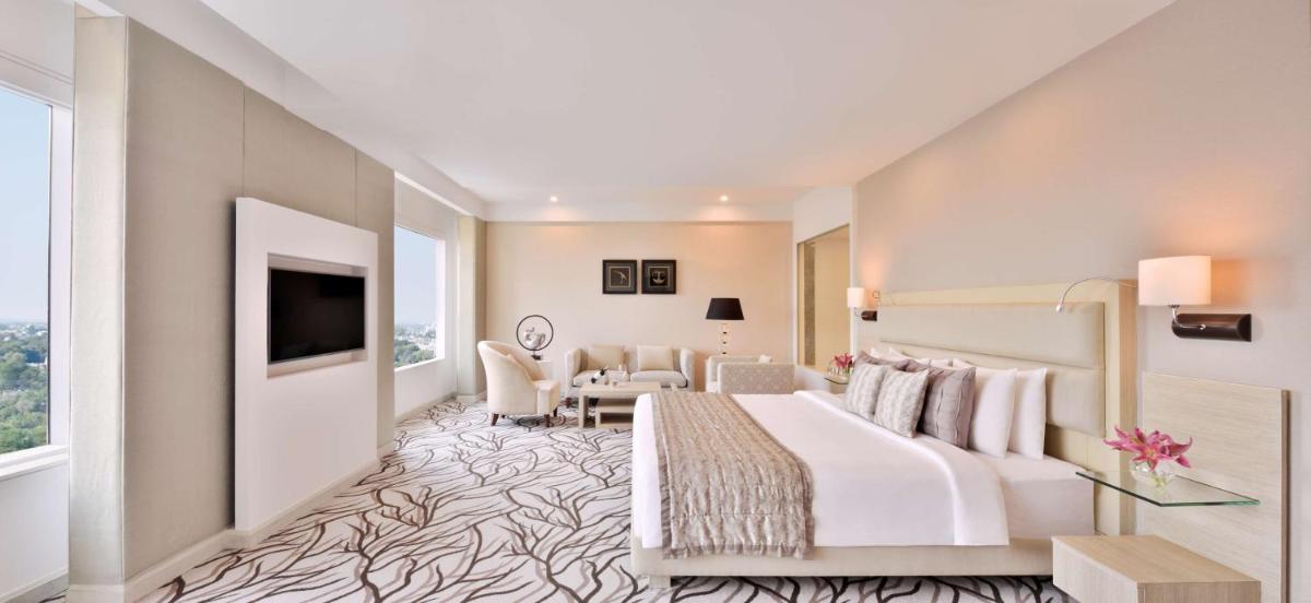 a hotel room with a bed and a living room at Radisson Blu Bengaluru Outer Ring Road in Bengaluru