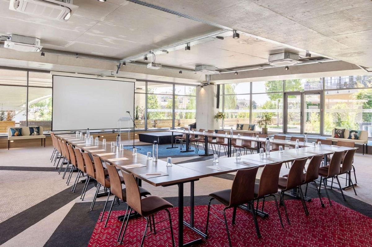 une grande salle avec des tables, des chaises et un tableau blanc dans l'établissement Aiden by Best Western T'aim Hotel & SPA, à Compiègne 76 autres photos