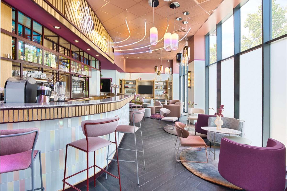 un restaurant avec des chaises violettes et un bar dans l'établissement Aiden by Best Western Clermont-Ferrand Hotel & Spa, à Clermont-Ferrand