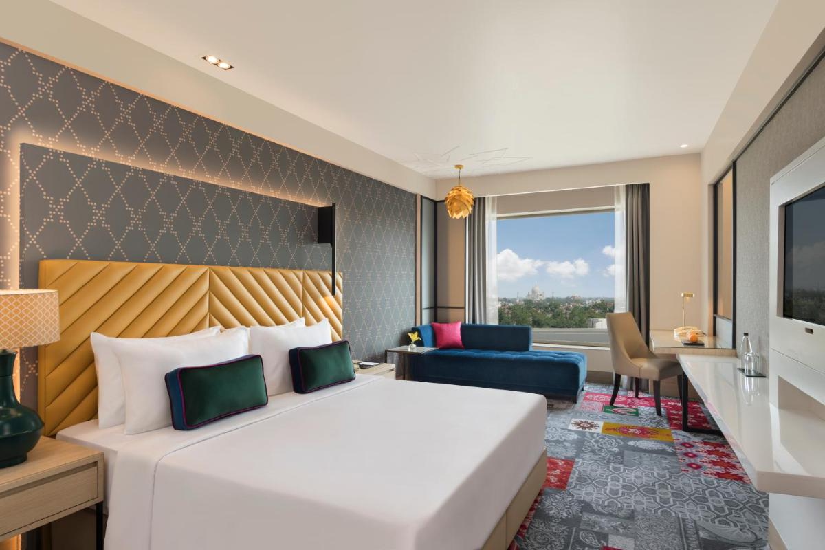 a hotel room with a bed and a desk at Grand Mercure Agra - An Accor Brand in Agra
