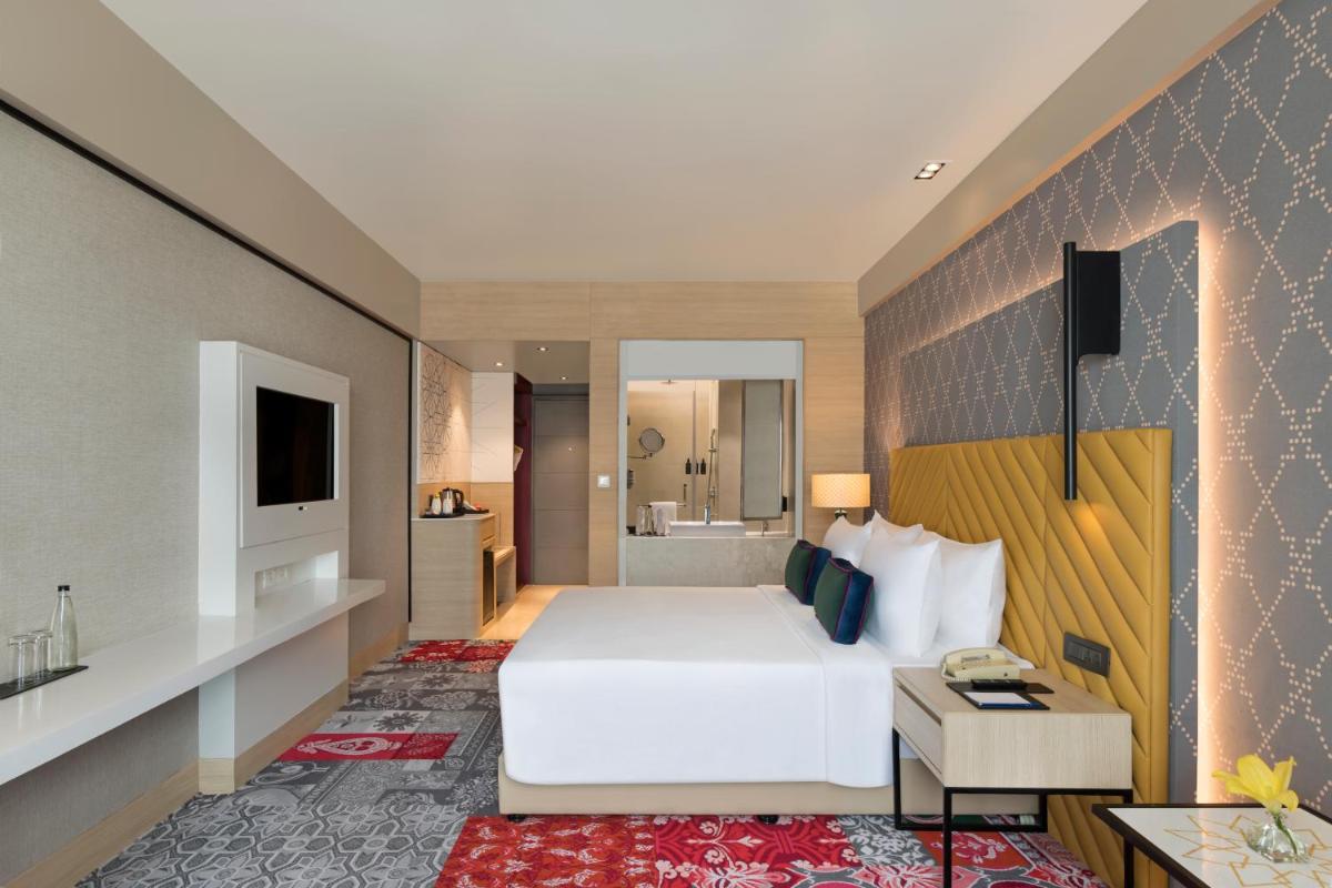 a hotel room with a bed and a bathroom at Grand Mercure Agra - An Accor Brand in Agra