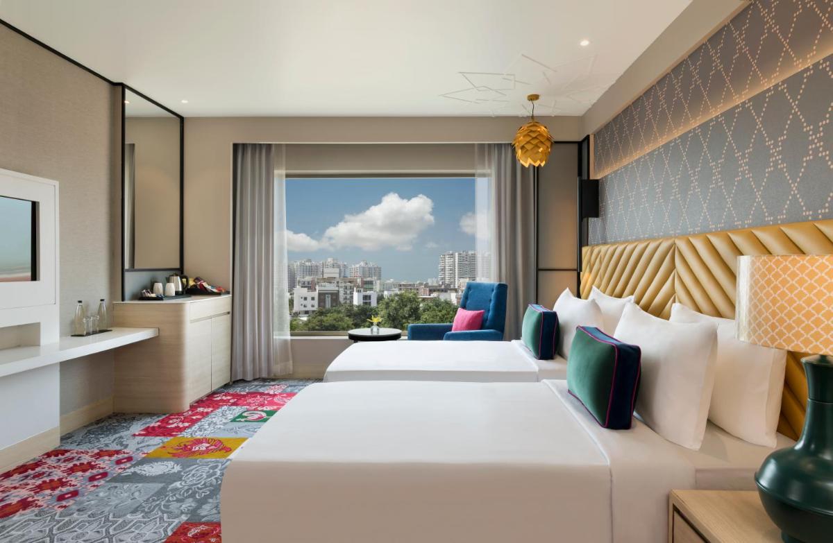 a hotel room with two beds and a large window at Grand Mercure Agra - An Accor Brand in Agra