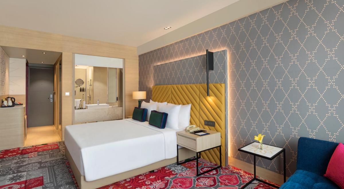 a hotel room with a bed and a bathroom at Grand Mercure Agra - An Accor Brand in Agra