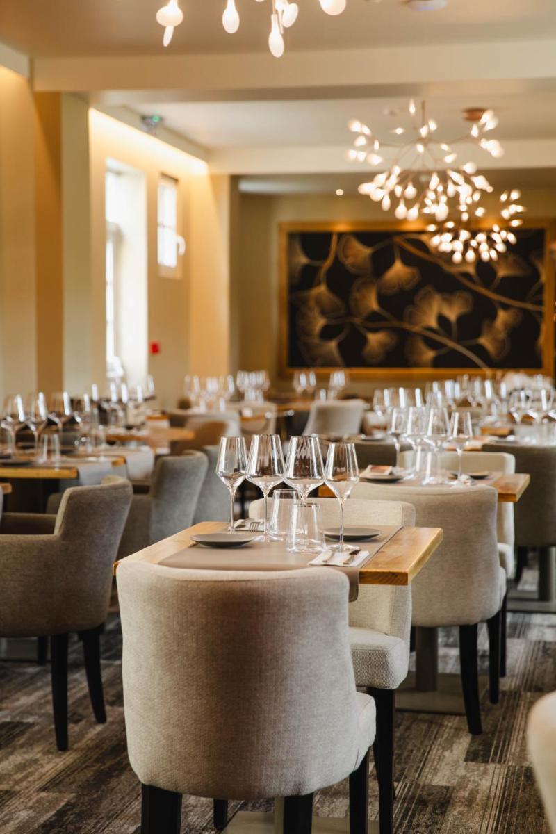 une salle à manger avec des tables, des chaises et des verres à vin dans l'établissement Le Castel Cabourg hôtel & SPA- Restaurant La Calypso, à Cabourg 54 autres photos