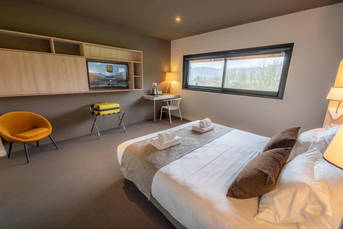 une chambre avec un grand lit et une fenêtre dans l'établissement Mildiss Hotel Spa & Restaurant, BW Signature Collection, à Besse-et-Saint-Anastaise
