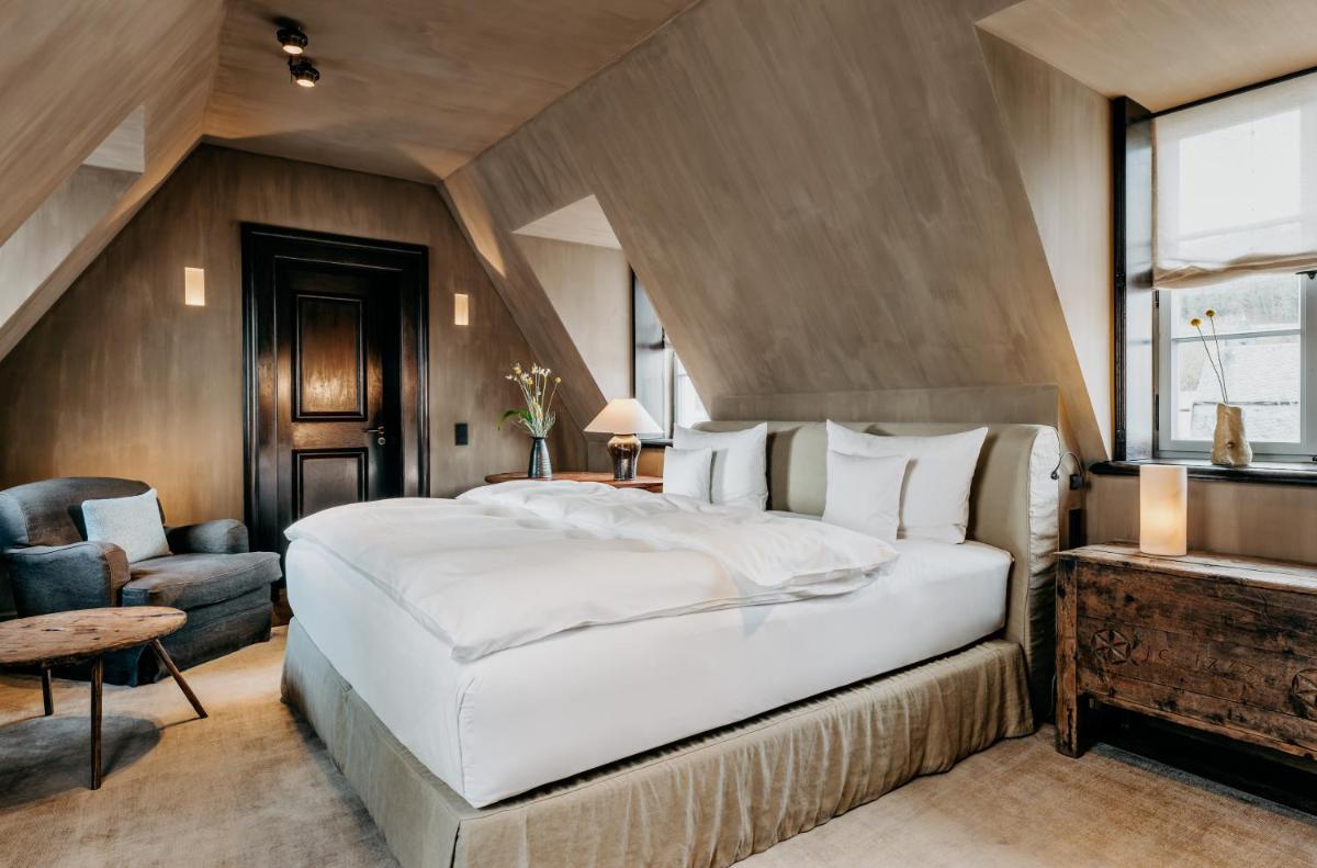 ein Schlafzimmer mit einem großen weißen Bett und einem Stuhl in der Unterkunft Hotel PURS in Andernach + 37 Fotos