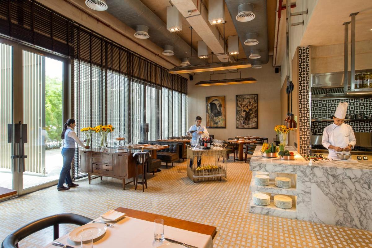 a restaurant with people standing around a counter in a room at Grand Hyatt Gurgaon in Gurgaon