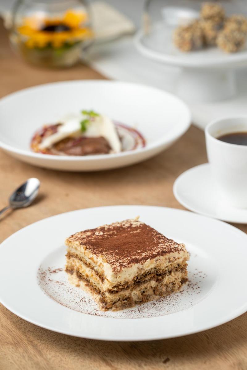 a piece of cake on a white plate on a table at Grand Hyatt Gurgaon in Gurgaon
