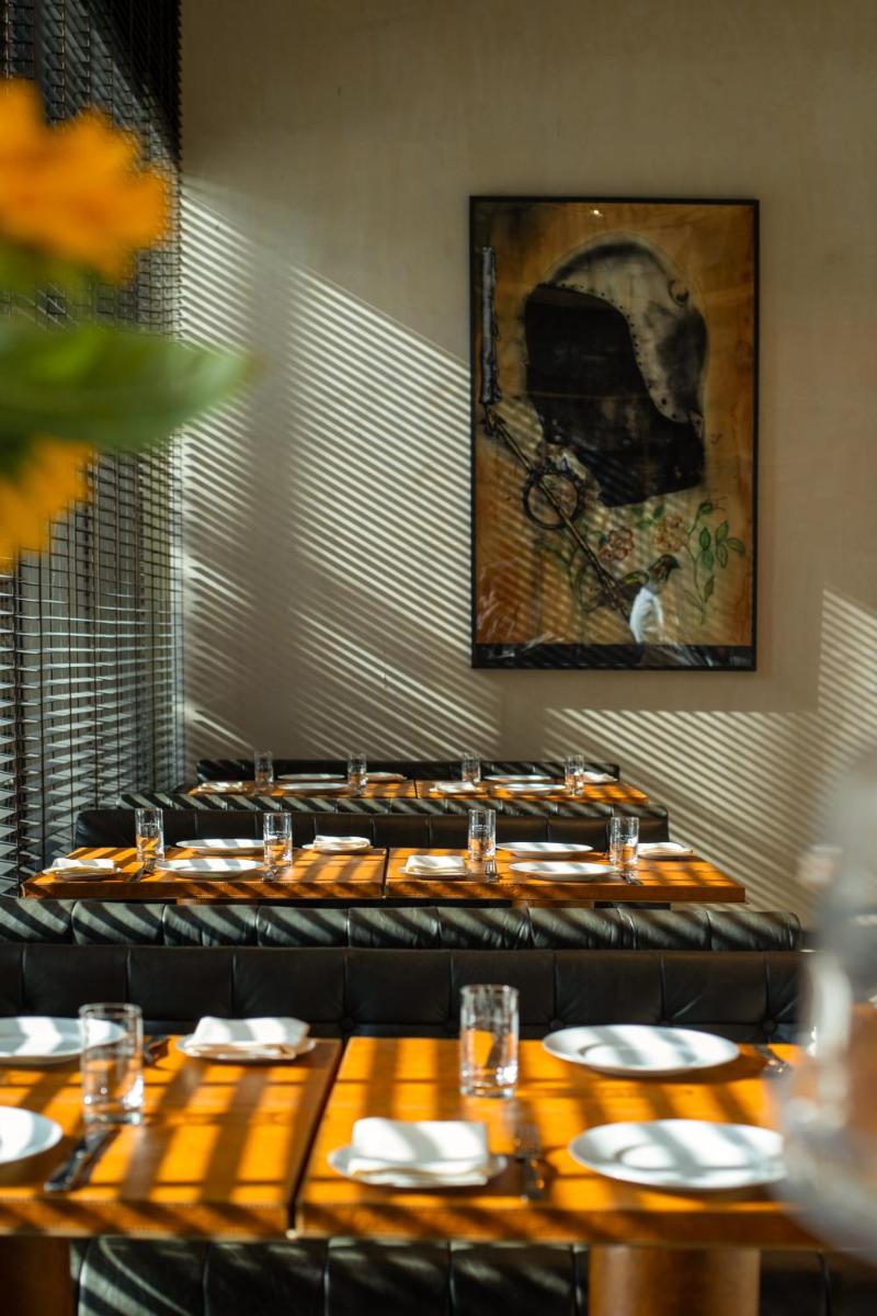 a dining room with tables and a painting on the wall at Grand Hyatt Gurgaon in Gurgaon