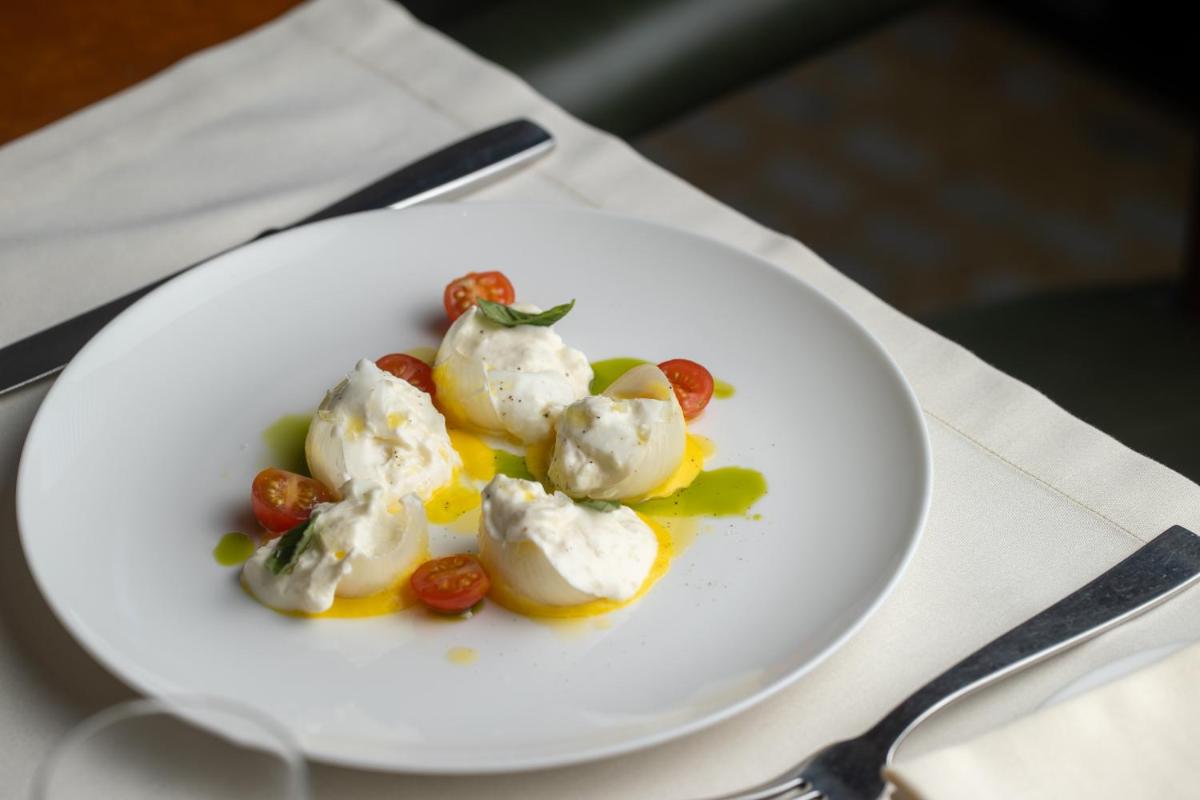 a white plate with ice cream and tomatoes on a table at Grand Hyatt Gurgaon in Gurgaon