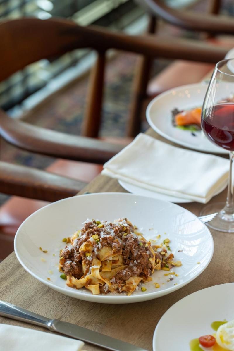 a plate of food on a table with a glass of wine at Grand Hyatt Gurgaon in Gurgaon