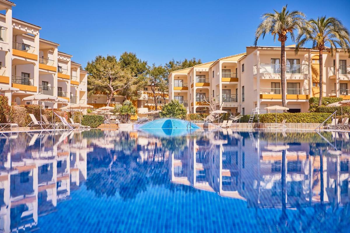 una piscina frente a unos edificios de apartamentos en Zafiro Tropic, en Puerto de Alcudia