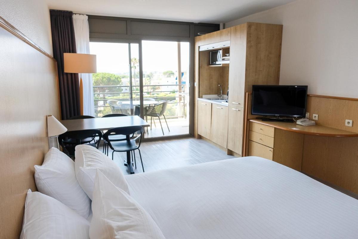 une chambre d'hôtel avec un lit et un bureau avec une télévision dans l'établissement Thalazur Antibes - Résidence & Spa, à Antibes 53 autres photos
