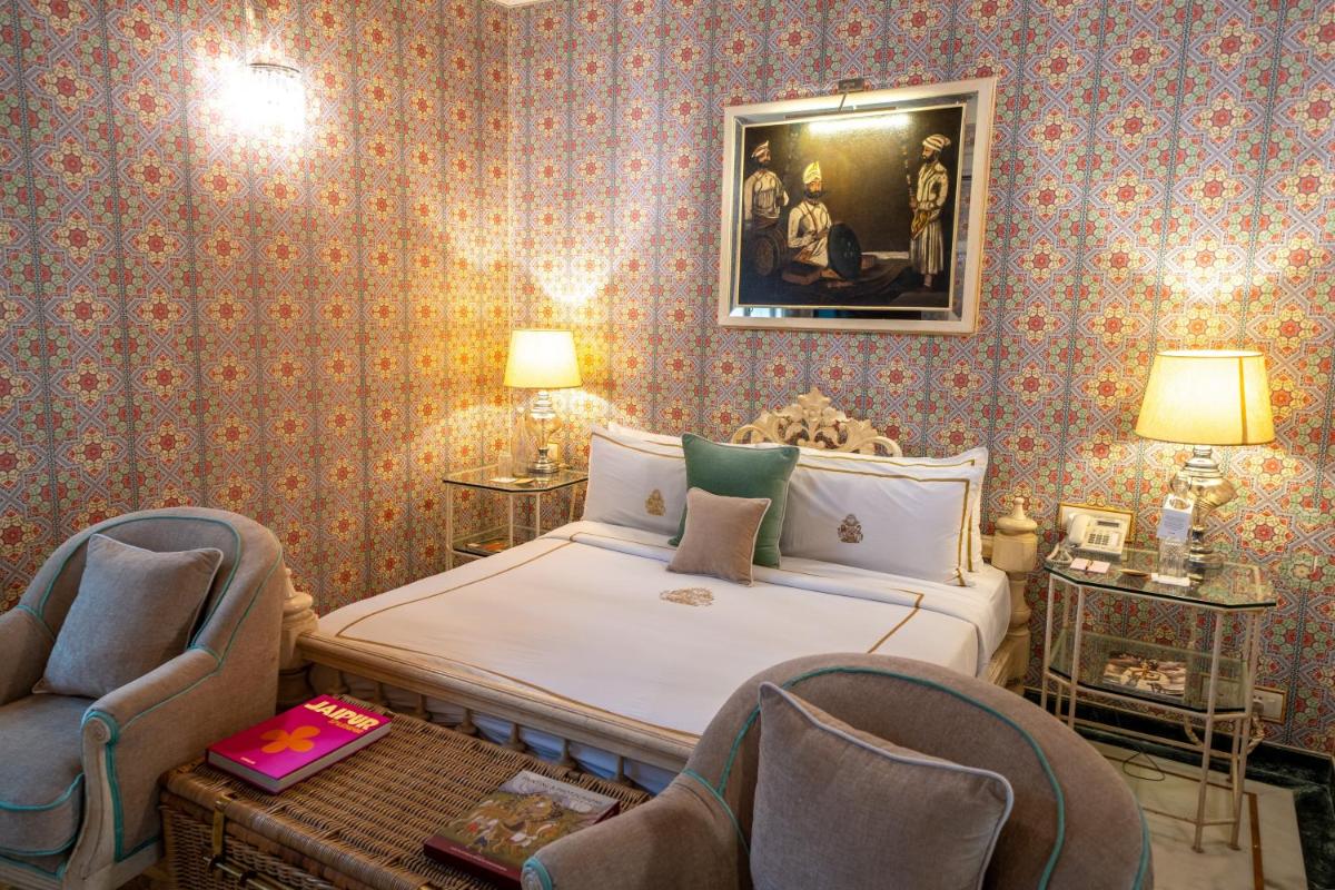 a bedroom with a bed and two chairs at Rajmahal Palace RAAS in Jaipur