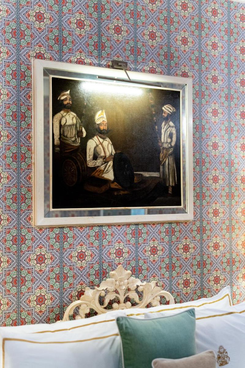 a painting of two men on a wall at Rajmahal Palace RAAS in Jaipur