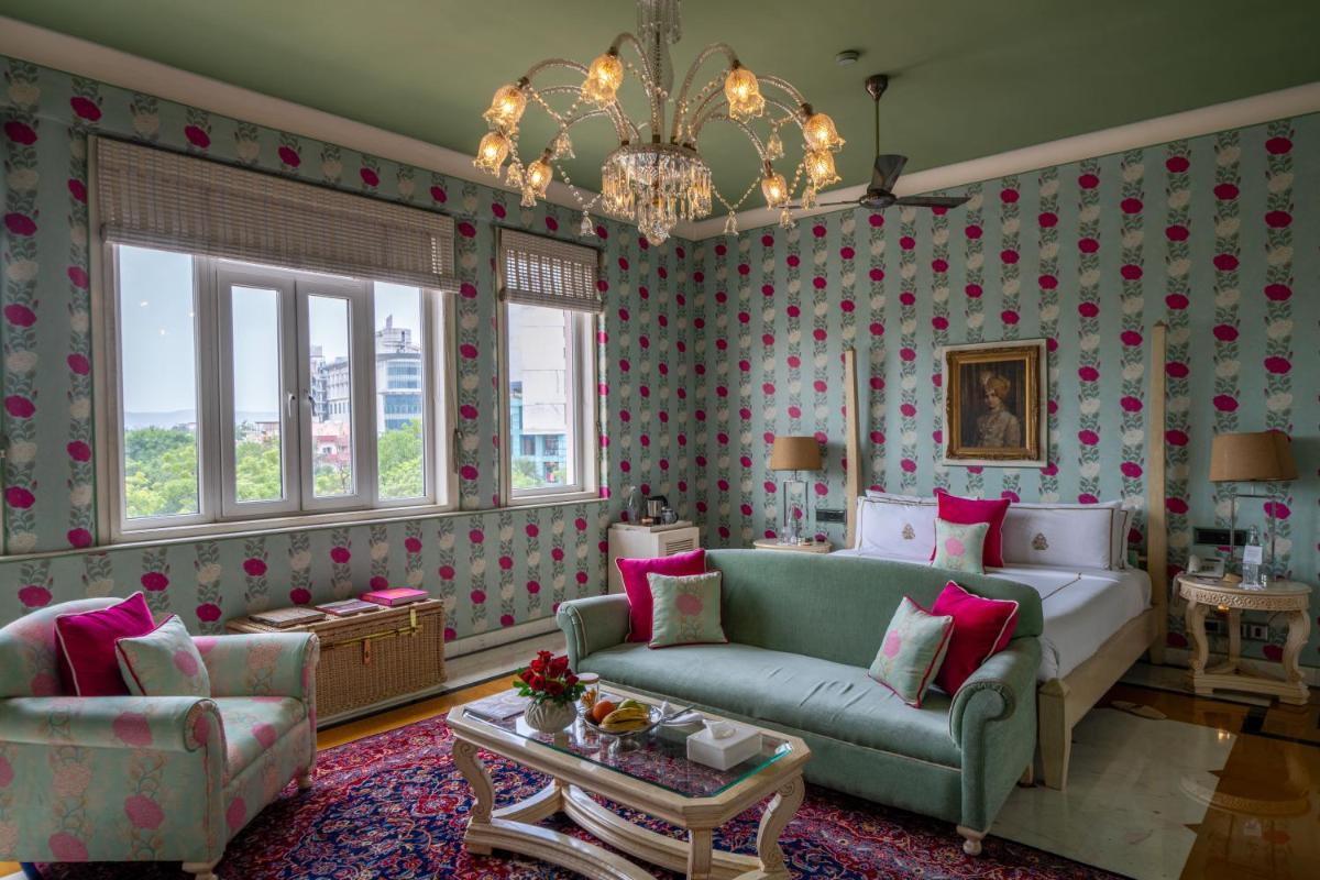 a living room with a couch and a chandelier at Rajmahal Palace RAAS in Jaipur