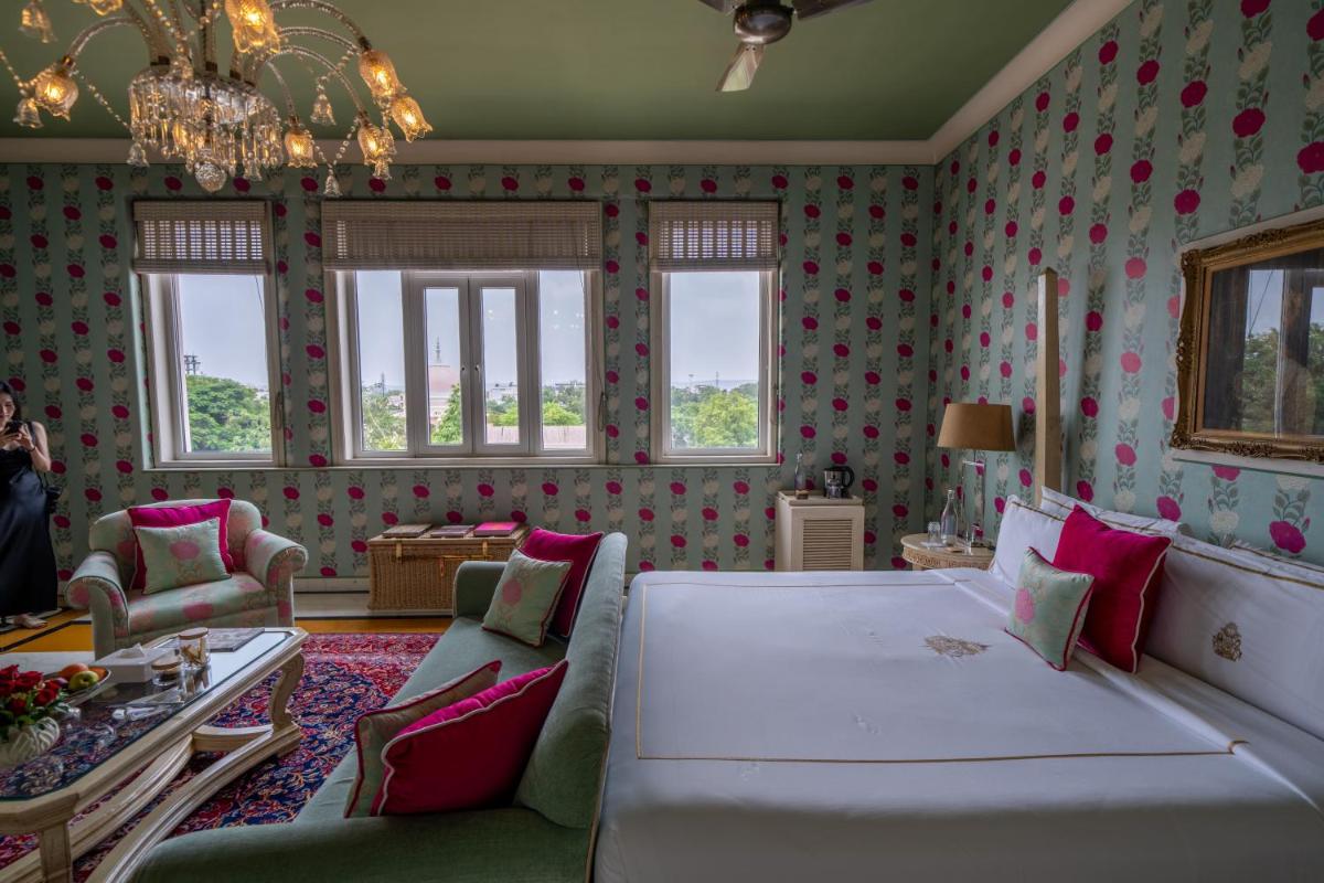 a living room with a large bed and a couch at Rajmahal Palace RAAS in Jaipur